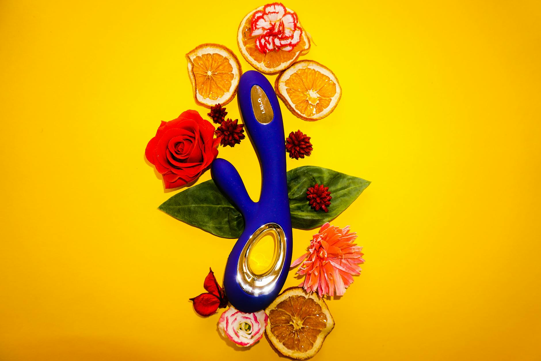 Vibrator clitoral ținut în mână pe fundal violet, reprezentând redescoperirea plăcerii și atingerea de sine